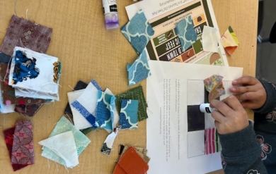 A photo of hands in the act of creating art with paper supplies.