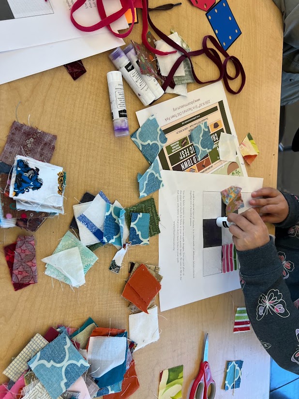 A photo of hands in the act of creating art with paper supplies.